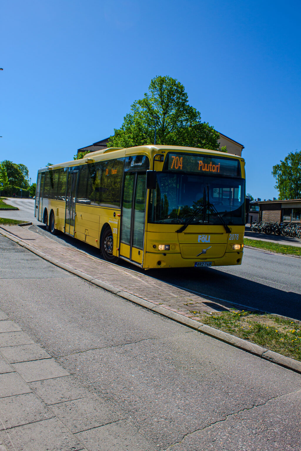 Keltainen Fölin linja-auto bussipysäkillä.
