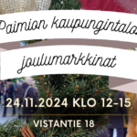 Paimion kaupungintalon joulumarkkinat, taustalla havukaranssi, jonka läpi näkyy ihmisiä.