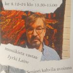 Jyrki Laine kuvattuna seinätekstiilin edessä.